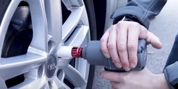 Changing the wheel on a car with an air impact wrench