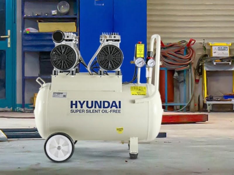 White Hyundai silent air compressor which is on the floor of a garage
